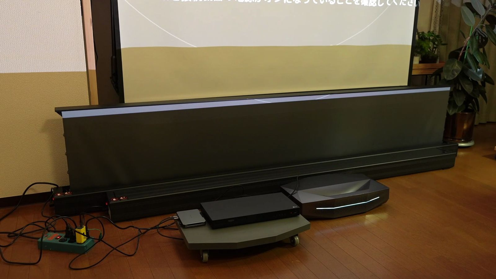 床に置いた本体から、グレーのスクリーンがせり上がっているところ