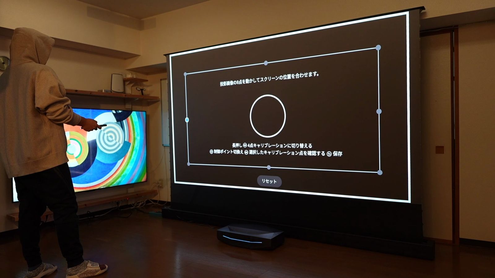 ポップアップスクリーンに投影した補正画面と、横で操作する人