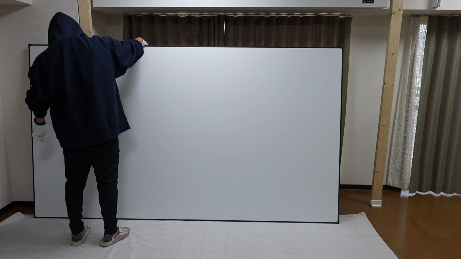 120インチの白いマットスクリーンを立てて支えているところ