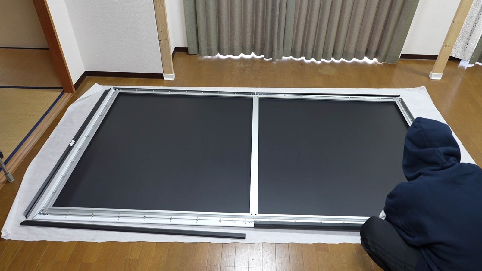 部屋の床で120インチのフレームを組み立てているところ