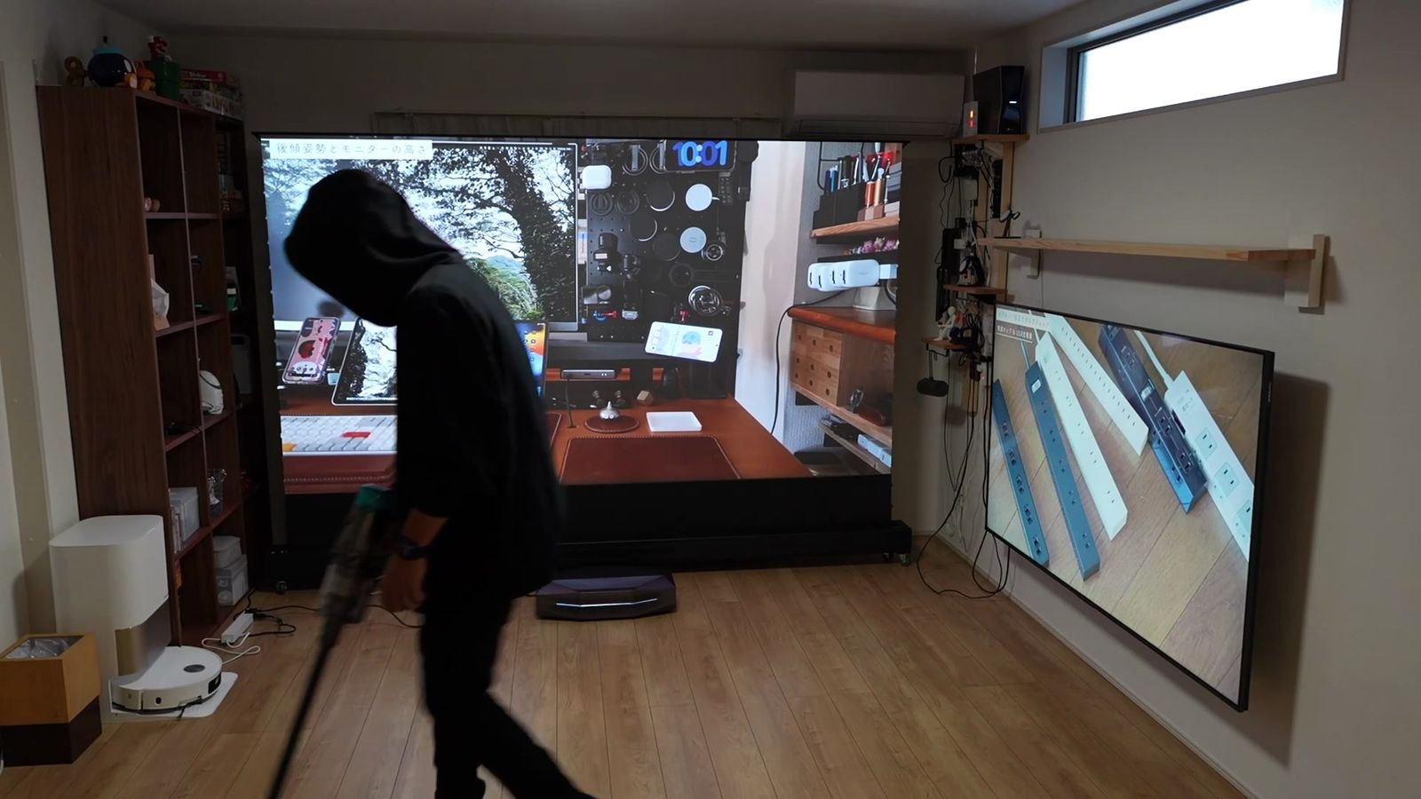 照明をつけた部屋で、スクリーンの前で掃除機をかけているところ