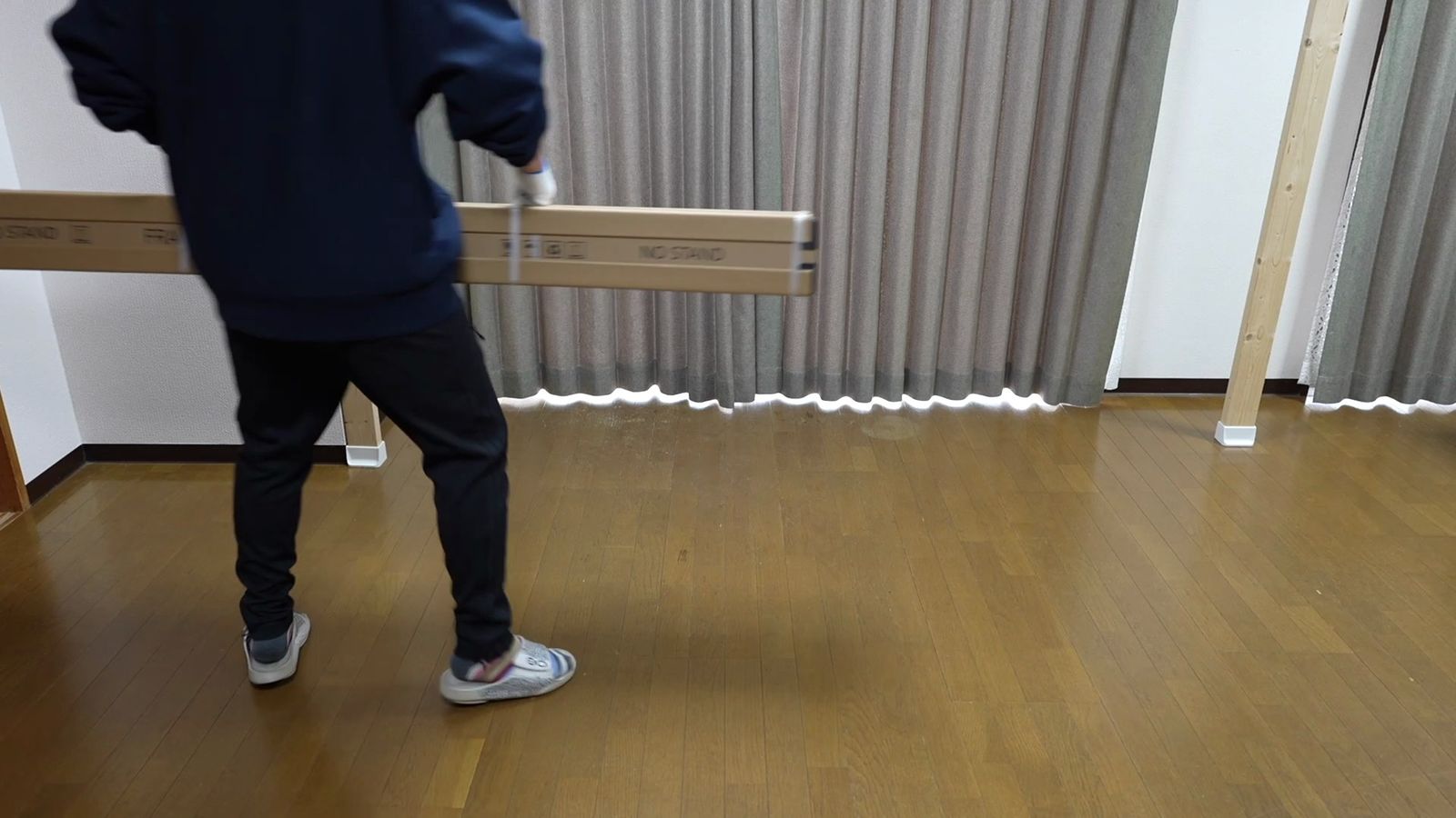 スクリーンの細長い箱を一人で運んでいるところ