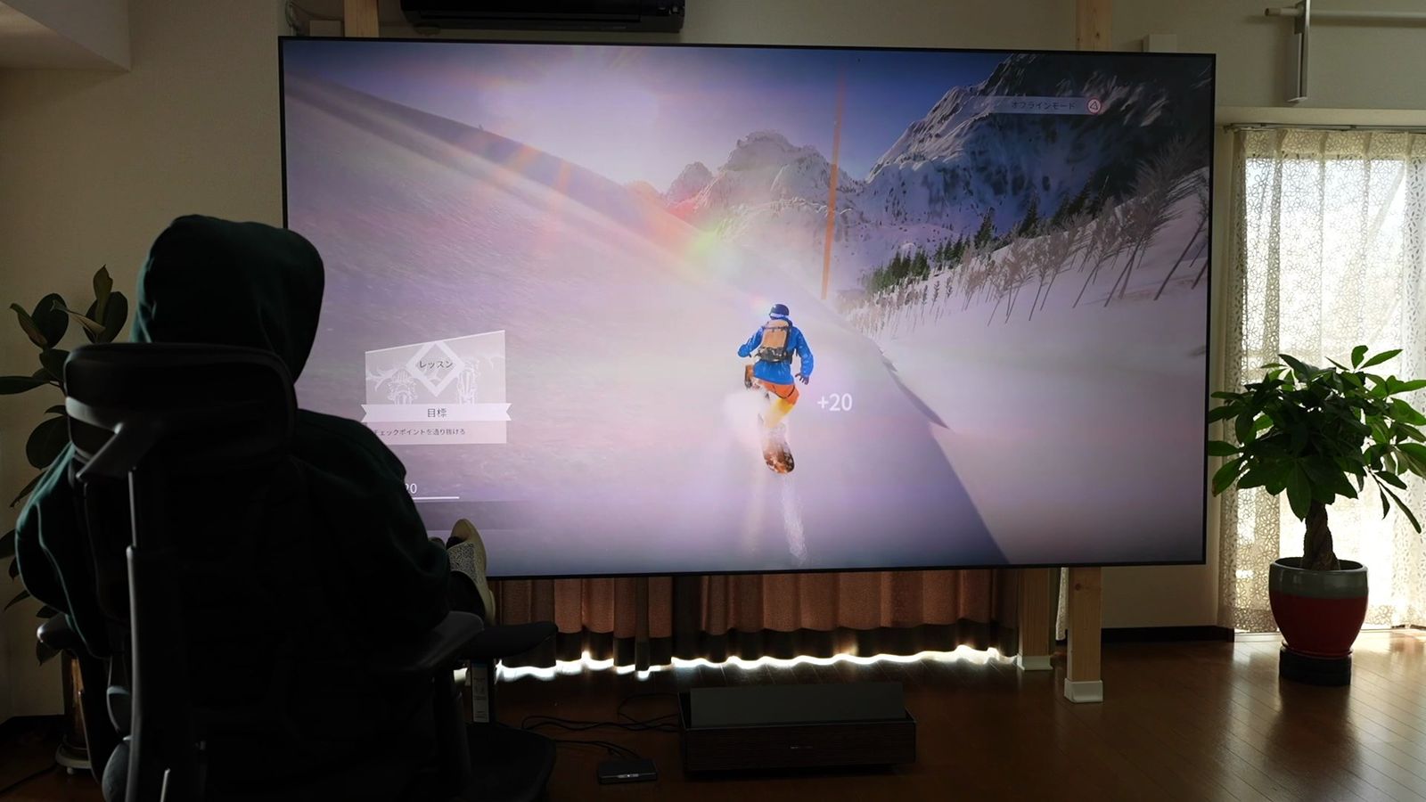 明るい部屋でAURA 3 Maxの映像をスクリーンに投影しているところ